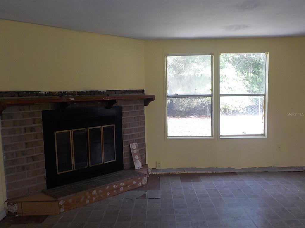 7445 Southwest 15th Place Ocala, FL 34474 - Photo 12 of 27 a living room with a fireplace and a window