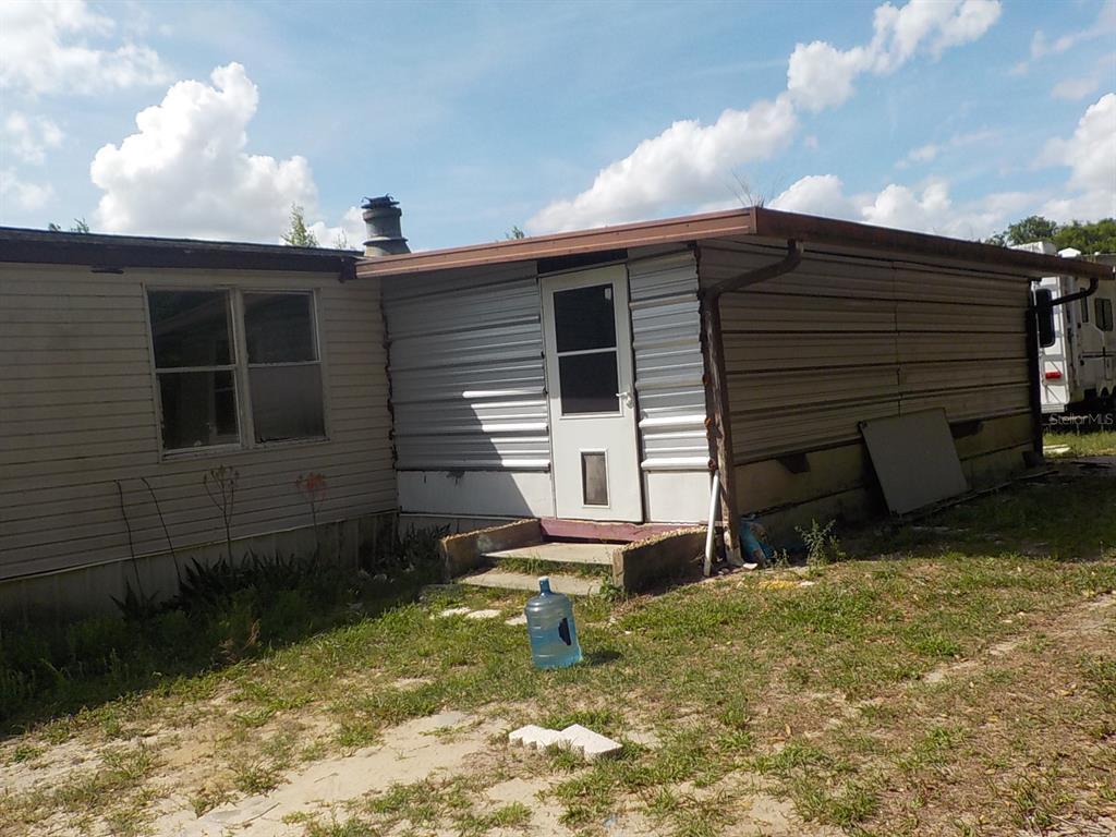 7445 Southwest 15th Place Ocala, FL 34474 - Photo 4 of 27 a view of backyard with a chair and potted plants
