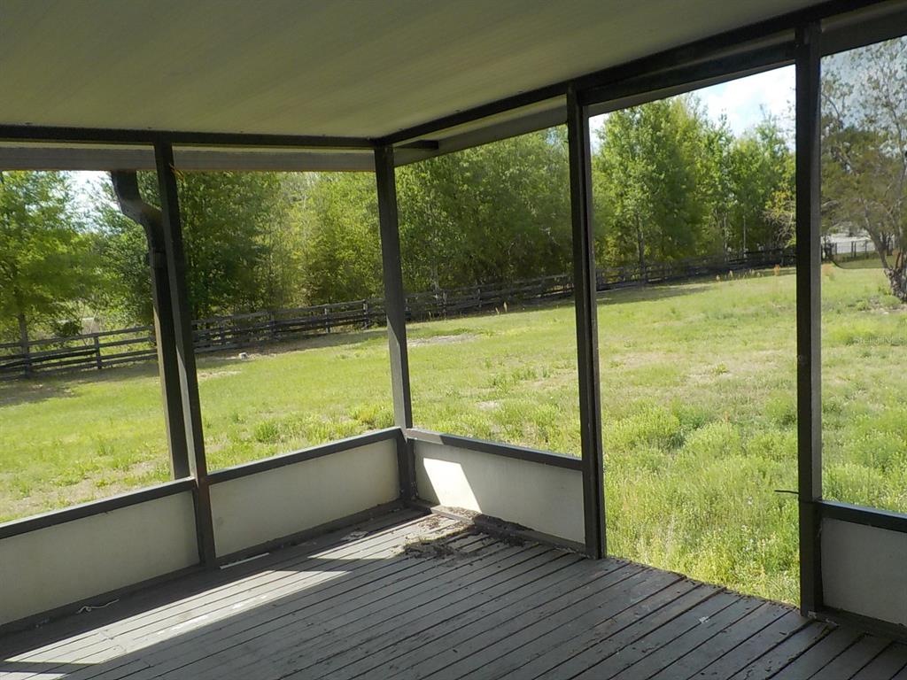 7445 Southwest 15th Place Ocala, FL 34474 - Photo 8 of 27 a view of an empty room with wooden floor and windows