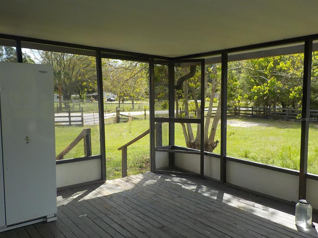 7445 Southwest 15th Place Ocala, FL 34474 - Photo 9 of 27 a view of empty room with wooden floor and floor to ceiling windows