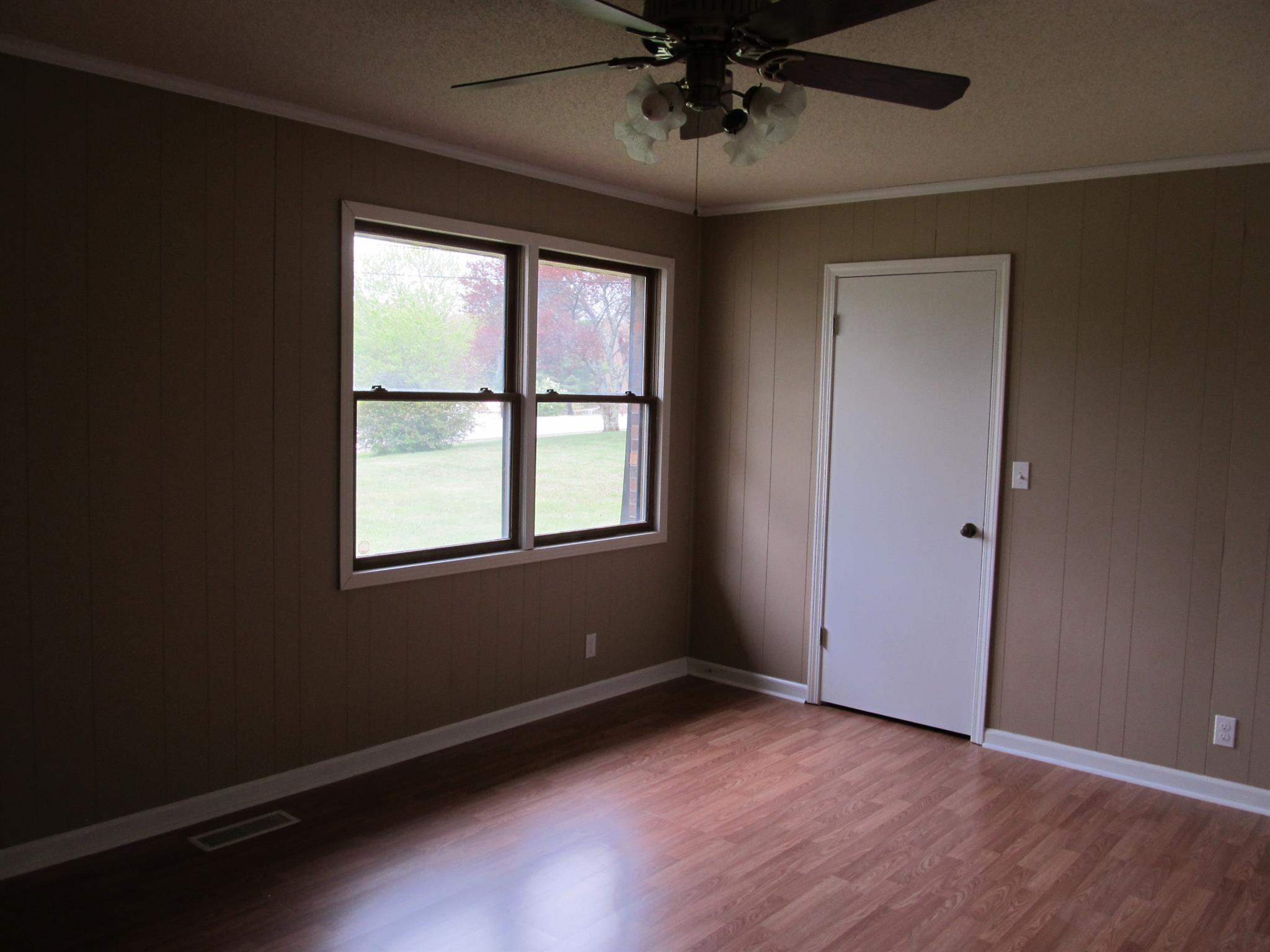 5452 Marion Road Cunningham, TN 37052 - Photo 7 of 15 an empty room with wooden floor chandelier and windows