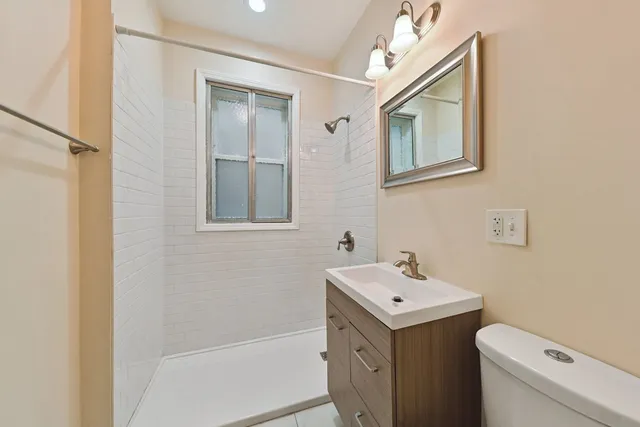 a bathroom with a sink mirror vanity and toilet