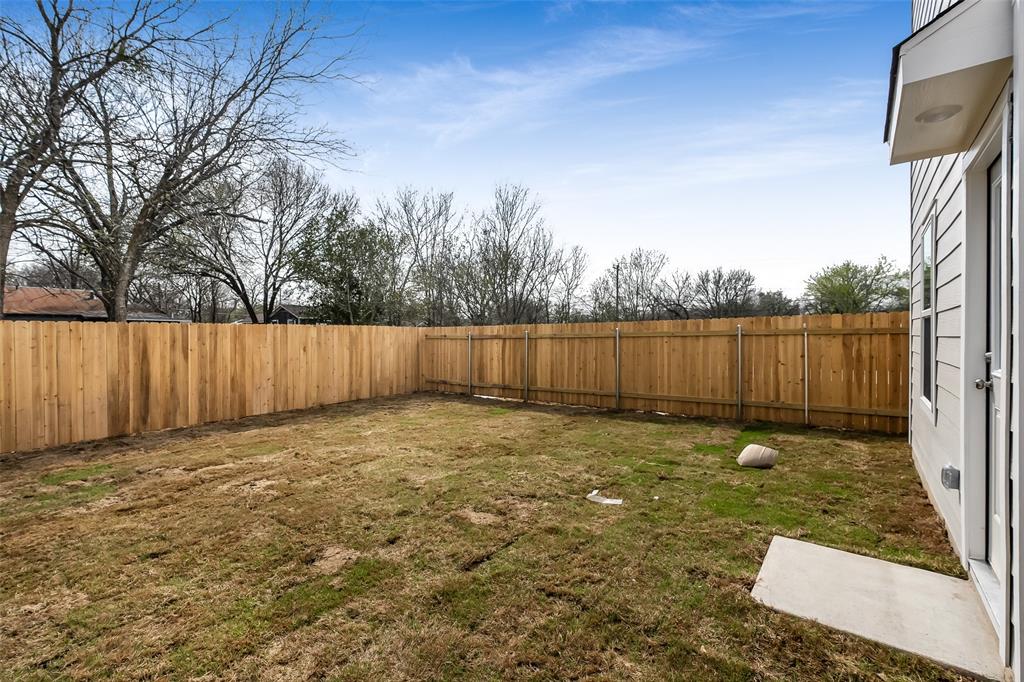 61 Trinity Circle Lockhart, TX 78644 - Photo 13 of 14 Expansive backyard with a new wood privacy fence, concrete patio, and white siding exterior