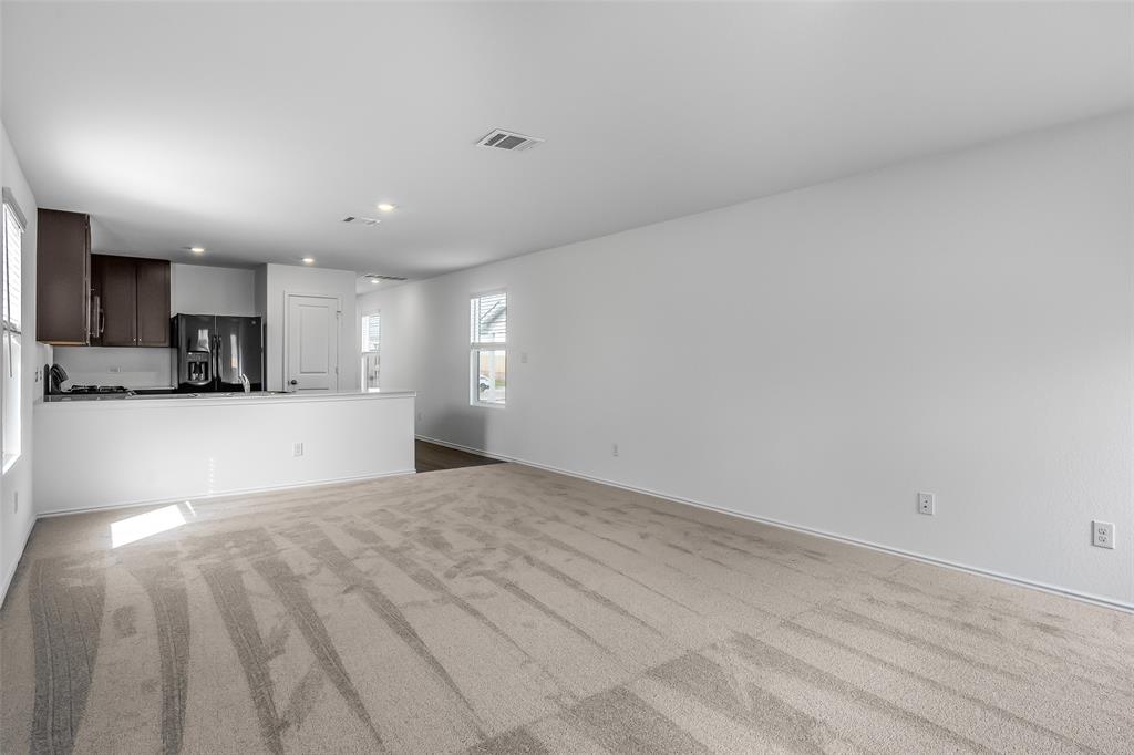 61 Trinity Circle Lockhart, TX 78644 - Photo 4 of 14 Open-concept living area featuring light-toned carpet and white walls