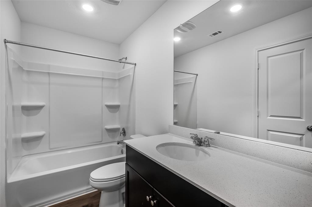 61 Trinity Circle Lockhart, TX 78644 - Photo 10 of 14 Bathroom featuring a dark wood-finish vanity with a light countertop, an integrated sink, and a chrome faucet