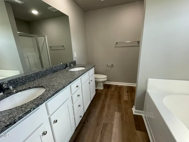 a spacious bathroom with a granite countertop sink and a mirror