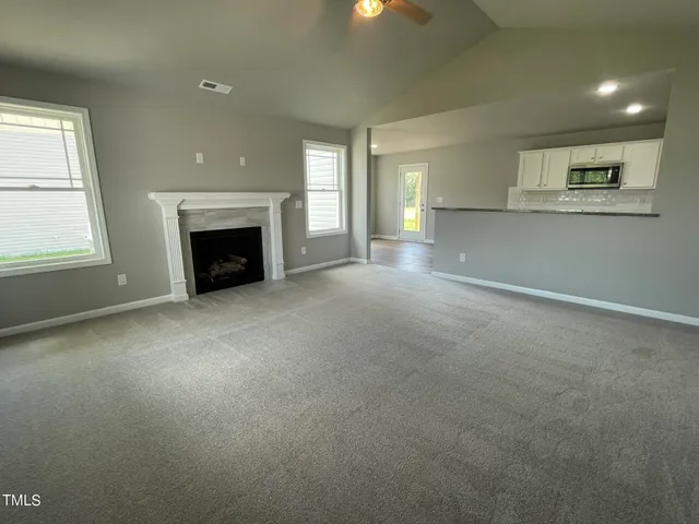 an empty room with a fireplace and windows