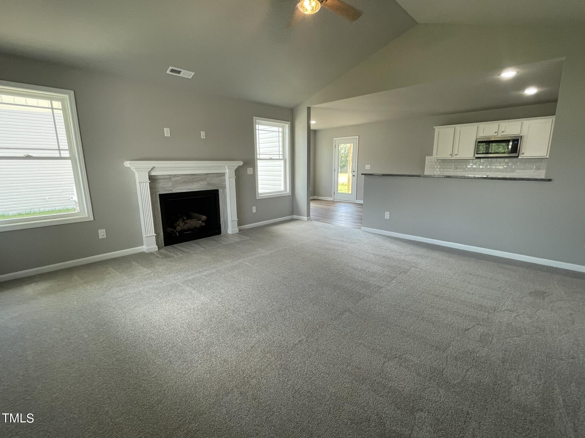 86 Scotties Ridge Drive Princeton, NC 27569 - Photo 2 of 19 an empty room with a fireplace and windows