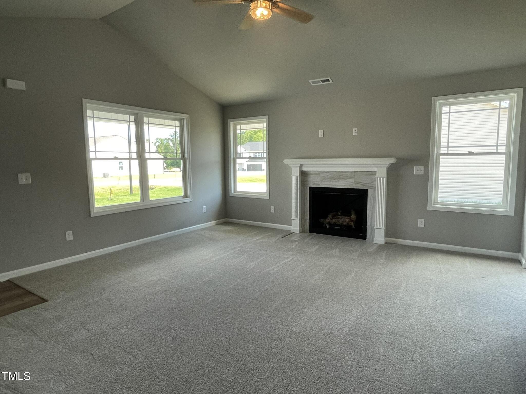 86 Scotties Ridge Drive Princeton, NC 27569 - Photo 3 of 19 an empty room with fireplace and windows