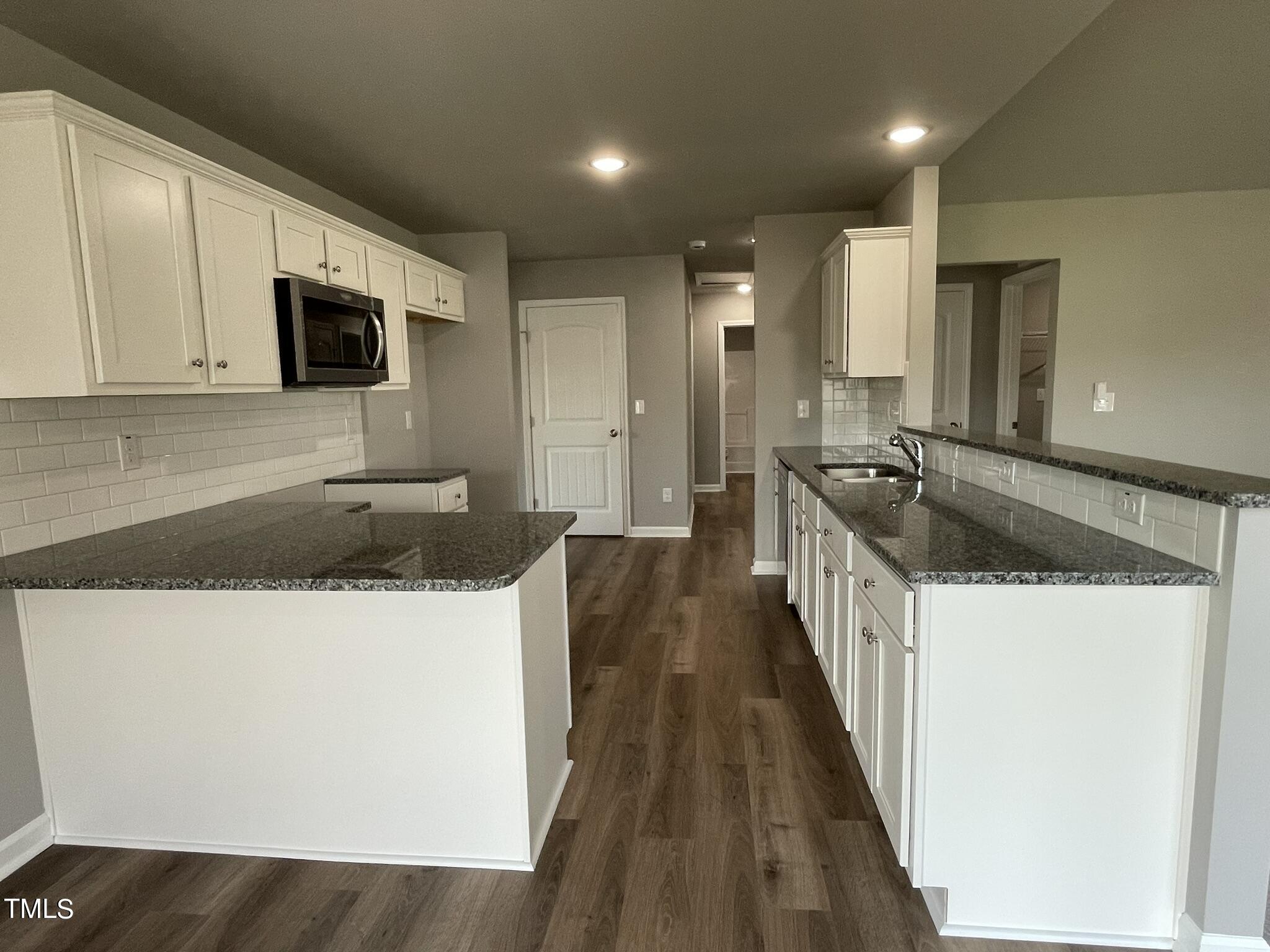 86 Scotties Ridge Drive Princeton, NC 27569 - Photo 4 of 19 a kitchen with granite countertop a sink a stove top oven a granite counter space and cabinets
