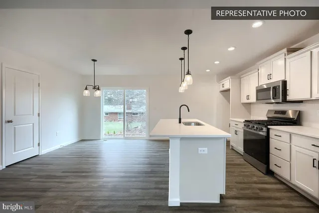a kitchen with stainless steel appliances granite countertop a sink a stove and a wooden floors