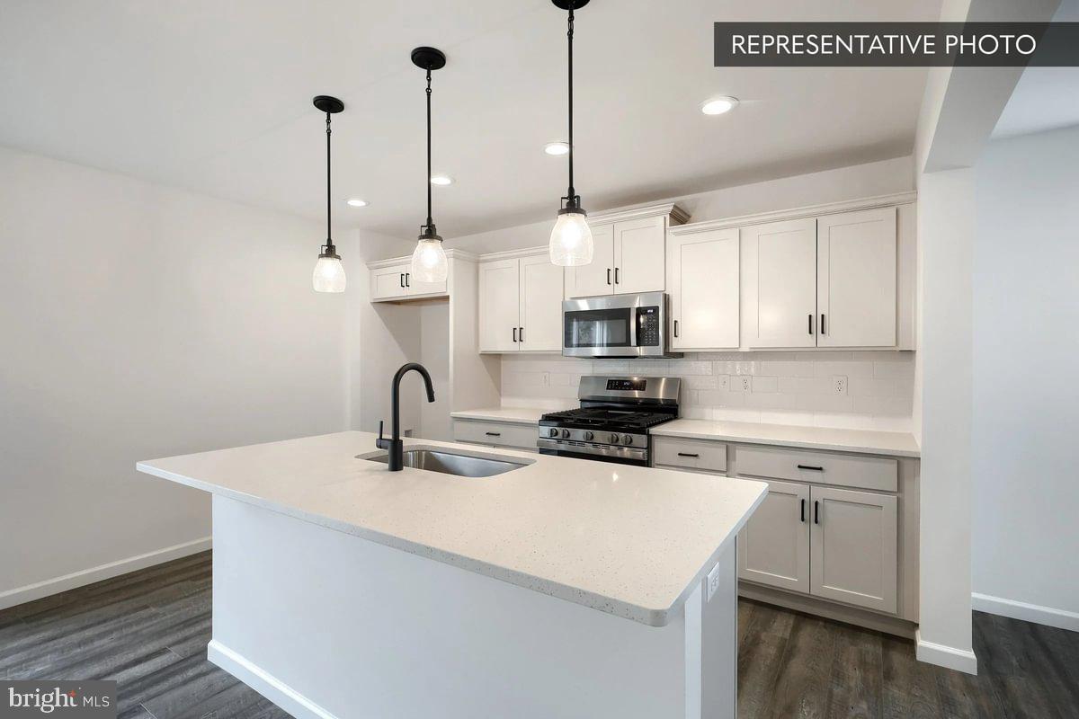 Pin Oak Plan At Hills Spring Grove, PA 17362 - Photo 8 of 38 a kitchen with stainless steel appliances kitchen island a white counter space a sink and cabinets