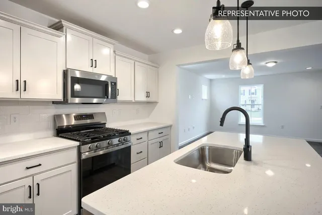 a kitchen with a sink a stove and microwave