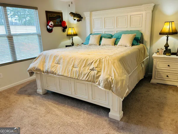 a bedroom with a bed and dresser with mirror