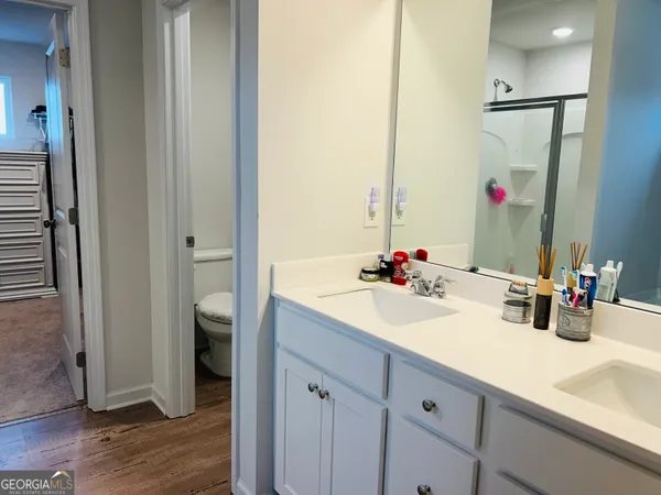 a bathroom with a double vanity sink mirror and shower