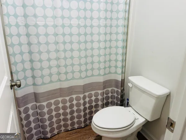 a white toilet sitting next to a white wall