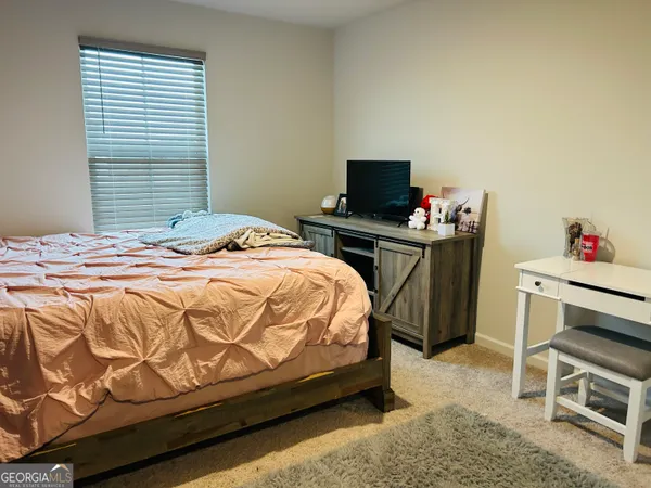 a bedroom with a bed and a television