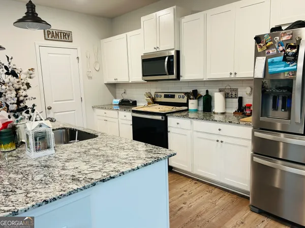 a kitchen with granite countertop a sink stove and refrigerator