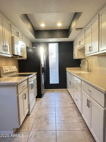 a large kitchen with stainless steel appliances kitchen island granite countertop a sink and cabinets