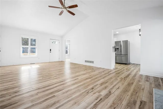 a view of empty room with wooden floor and window