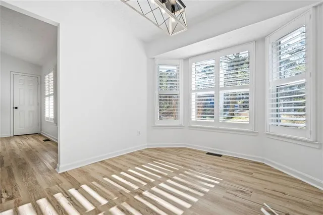 a view of a room with wooden floor and windows