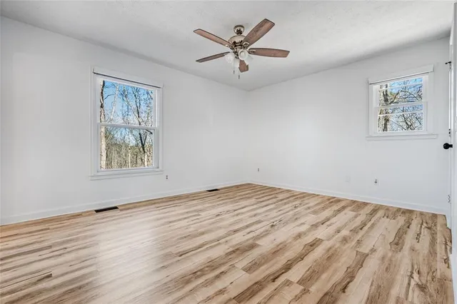 a view of an empty room with a window and a ceiling fan