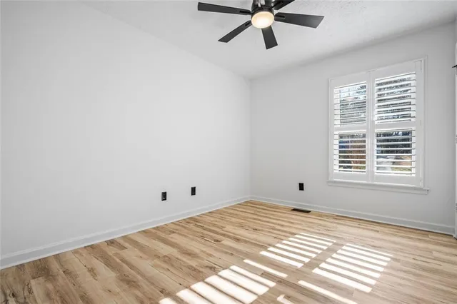 a view of a big room with wooden floor and windows