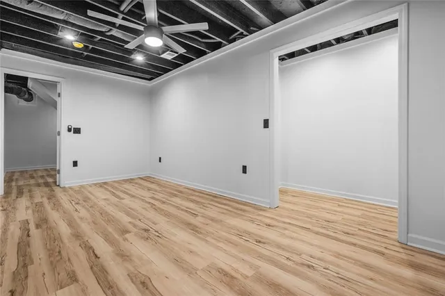 a view of empty room with wooden floor