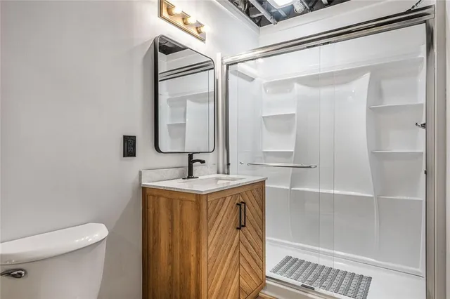 a bathroom with a sink a toilet and shower
