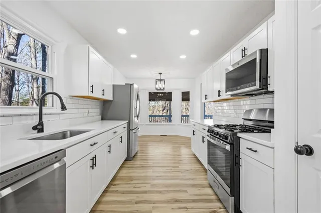 a large kitchen with stainless steel appliances granite countertop a sink and a stove