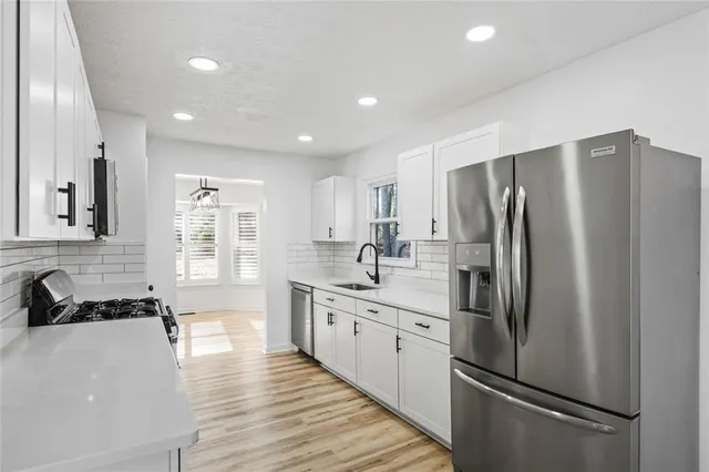 a kitchen with stainless steel appliances a refrigerator sink and cabinets