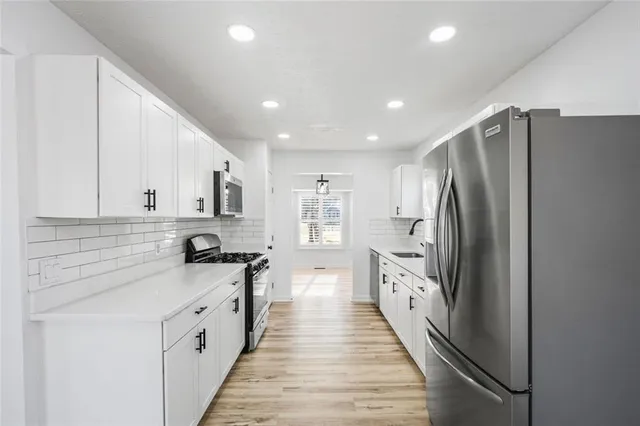 a large white kitchen with stainless steel appliances