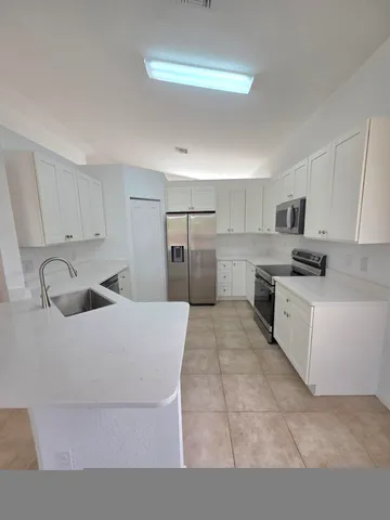 a kitchen with white cabinets and stainless steel appliances