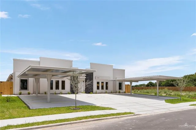 a view of a house with a big yard and large tree
