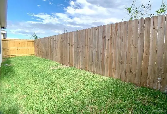 a view of a backyard with wooden fence