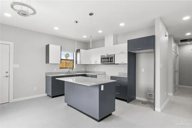 a kitchen with stainless steel appliances kitchen island granite countertop a refrigerator and a stove top oven