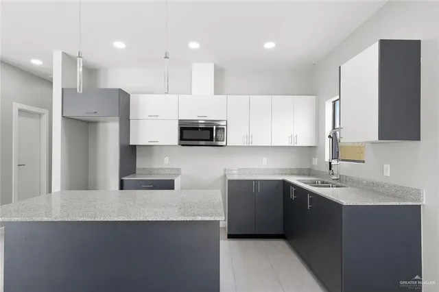 a kitchen with stainless steel appliances granite countertop a sink a stove a refrigerator and cabinets