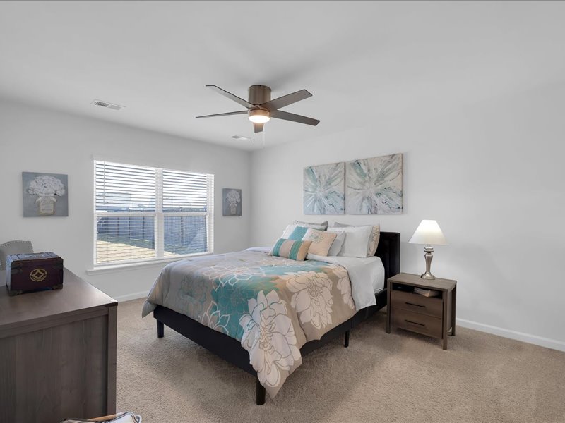 525 Ashwood Way Easley, SC 29640 - Photo 16 of 36 This inviting bedroom features soft carpeting, a bright window, and a ceiling fan for comfort.