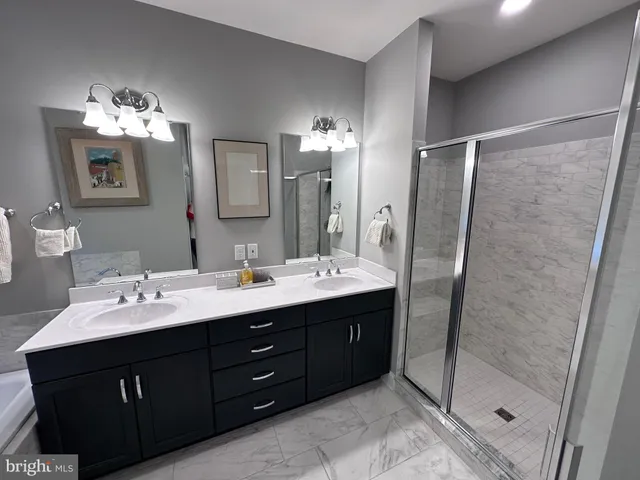 a bathroom with a double vanity sink mirror and shower
