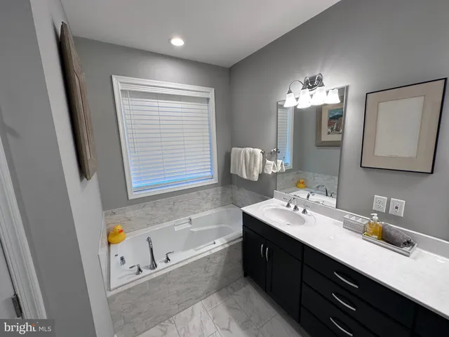 a bathroom with a tub sink and mirror