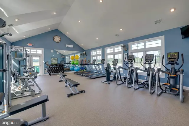 a kitchen with stainless steel appliances kitchen island granite countertop a table chairs sink and cabinets