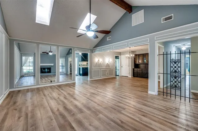 a view of a hallway with wooden floor and a kitchen