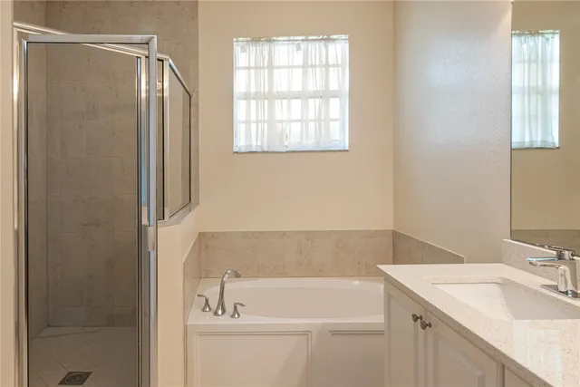 a bathroom with a tub sink and mirror