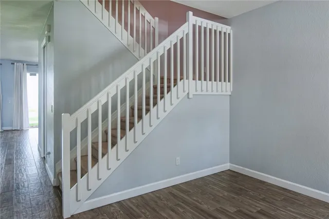 a view of staircase with wooden floor and white walls