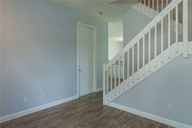 a view of staircase with wooden floor and white walls