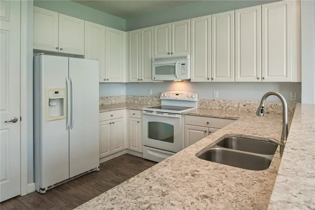 a kitchen with white cabinets sink and white stainless steel appliances
