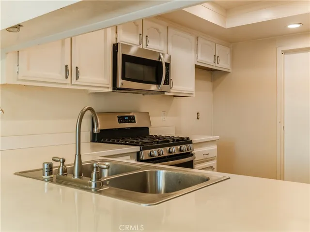 a kitchen with stainless steel appliances granite countertop a sink a stove and microwave