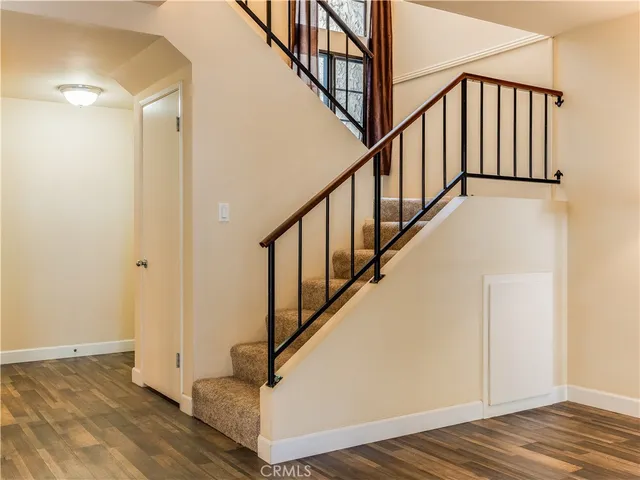 a view of staircase with wooden floor and white walls