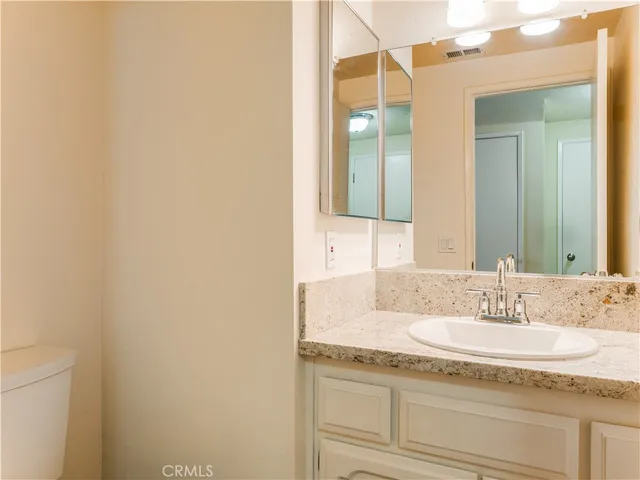 a bathroom with a granite countertop sink and a mirror