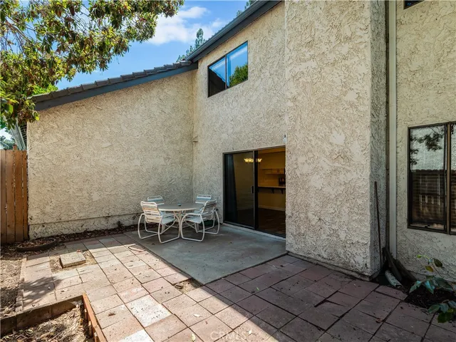 a backyard of a house with barbeque oven table and chairs